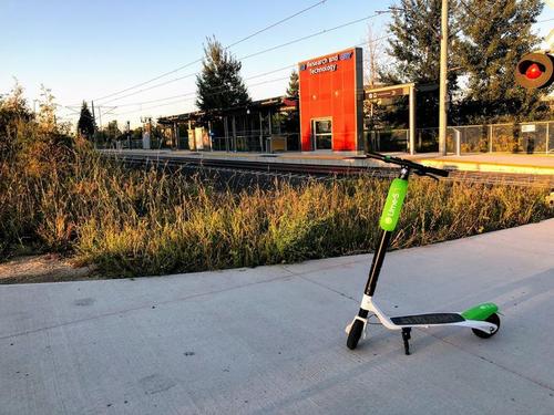 A lime scooter in front of an LRT stop