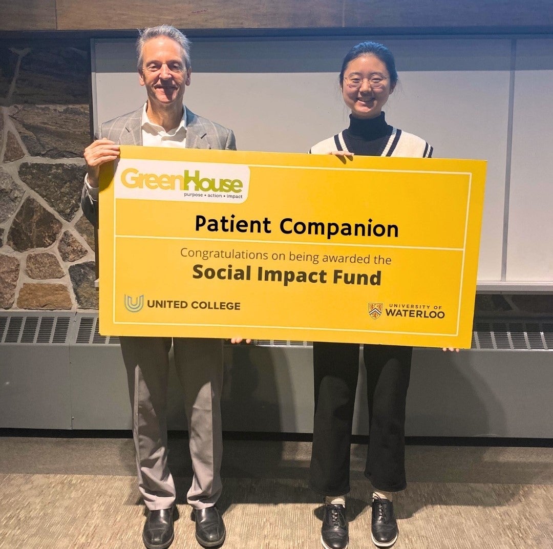 Christy Lee receiving the Social Impact Fund from United College principal Richard Myers