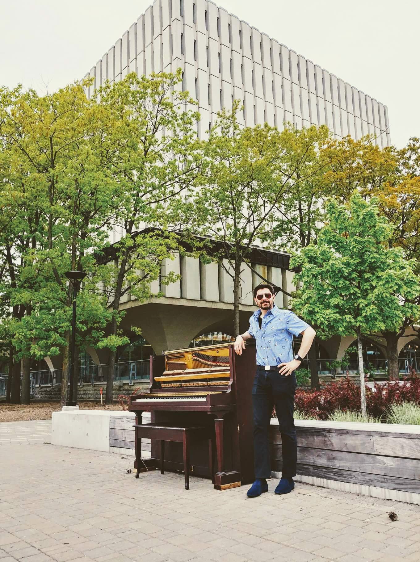 Max Salman standing beside piano