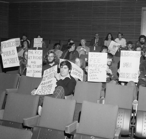 Students hold up signs in protest of fee hikes, circa 1972
