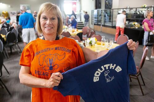 Alum holds up old t-shirts from residence