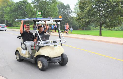 Feridun Hamdullahpur, left, and Alex Rodrigues in a self-driving golf cart during a 2015 demonstration.