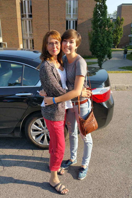 Jocelyn and her mother hugging in front of Village 1 residence on move in day
