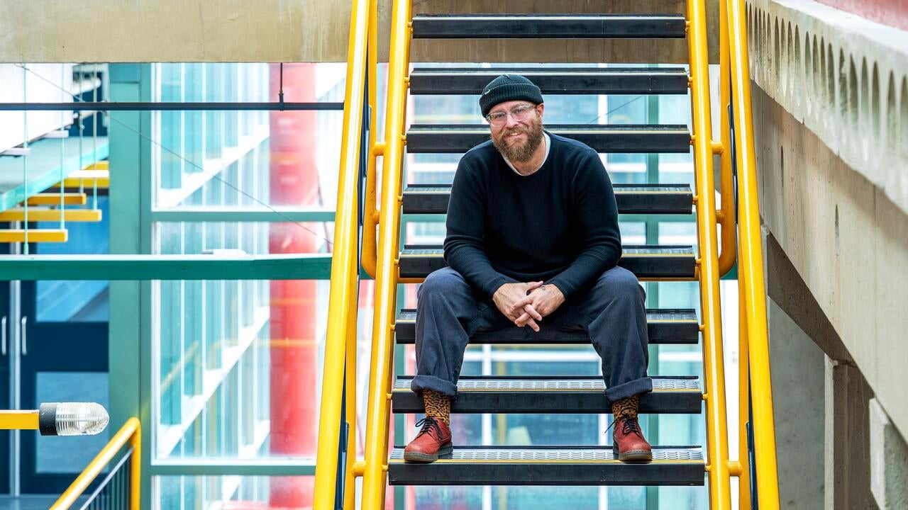 Zach Mckendrick sitting on stairs in open space