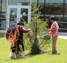 Elder Henry and Dean Liu watering cedar tree