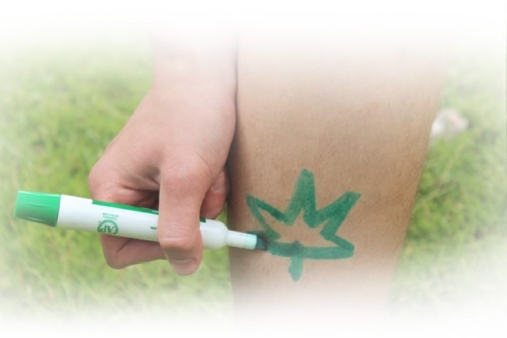 Hand drawing maple leaf in green Suncayr marker on leg
