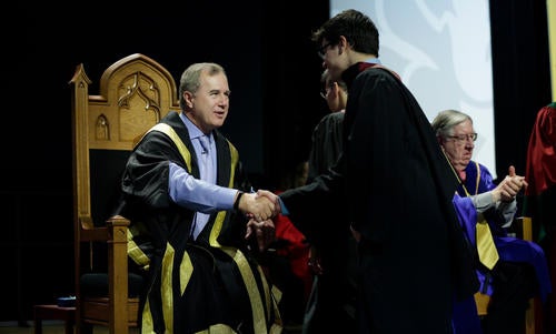 Tom Jenkins shakes the hand of a student