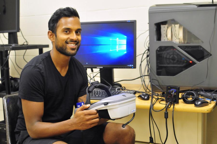 Robin Mazumder showing the virtual reality headset and equipment he uses in his research