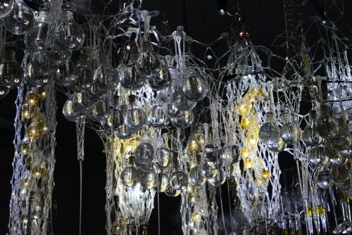 art installation of pendulus bulbs and mesh