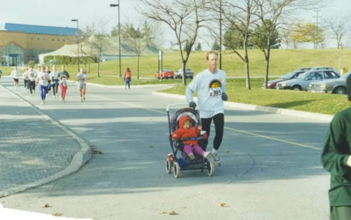 Father pushes a stroller while running in the race
