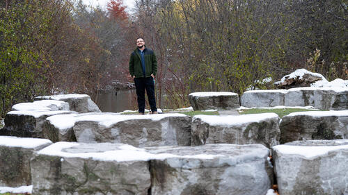 Kian Drew poses near a fire circle on the campus of the University of Waterloo