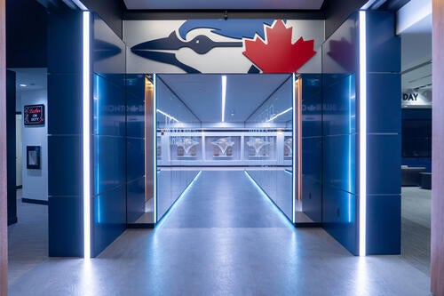 Inside Blue Jays clubhouse featuring mirrored hallway with World Series trophies