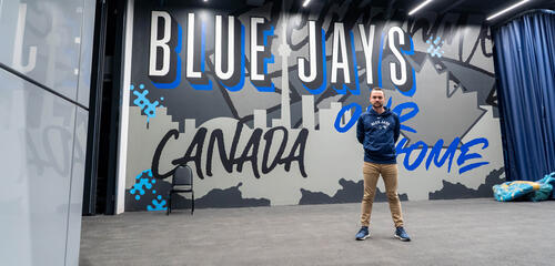 Jeremy Reesor stands in front of a graffiti sign on the lower concourse of Rogers Centre