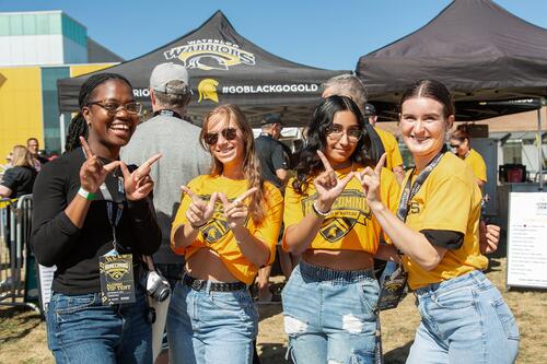 Young alumni make Ws with their hands