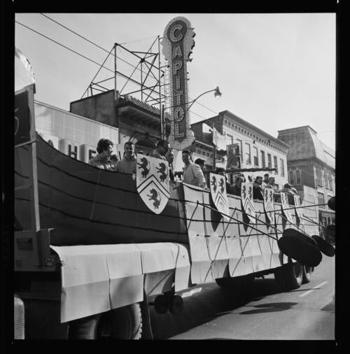 A parade float with oars drives along King Street