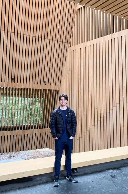 Thomas Coleman poses at the Audian Art Museum surrounded by wood panelling