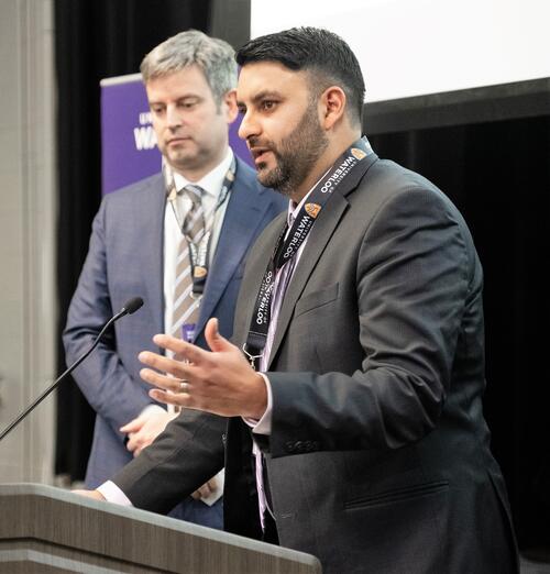 Aman Thind addresses the audience at Federation Hall while Brian Courtney, his partner at Convai Medical, looks on.