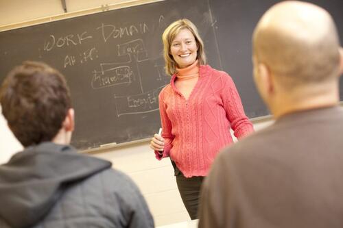 Catherine Burns at the chalkboard in front of a class of students