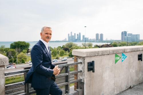 Chris Hadfield leans on railing overlooking cityscape