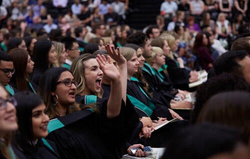 Waterloo graduates cheering while seated for convocation 