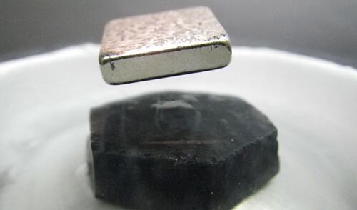 A magnet levitating above a cuprate high temperature superconductor.