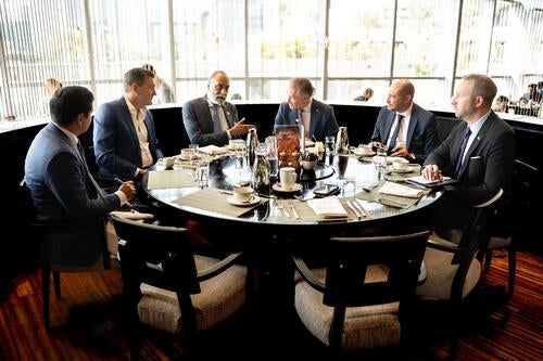 Group of men including Mark Schaan and Evan Solomon are seated at a table in conversation