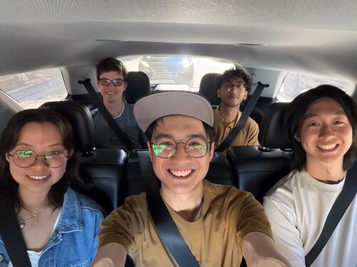 Atoms co-op students pose for selfie inside a minivan