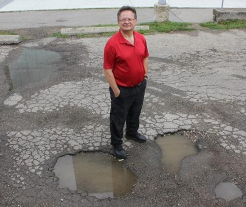 John Zelek standing beside potholes in the ground