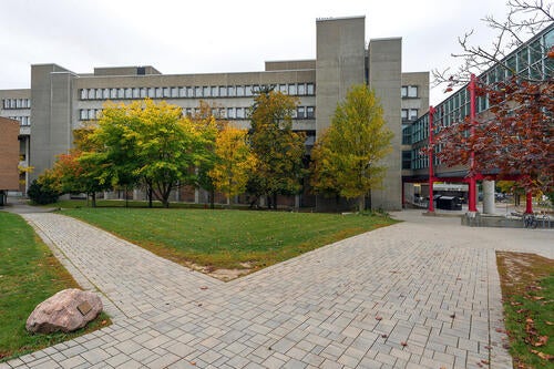 A view of the Math and Computer building in the fall, with two footpaths crossing in front of it