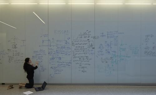 A student writes on a wall in the Quantum-Nano Centre