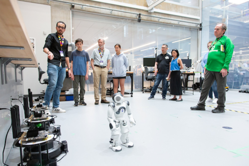 Visitors surrounding a robot on the ground