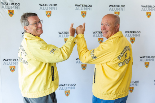 Two alum wearing old University of Waterloo jackets 