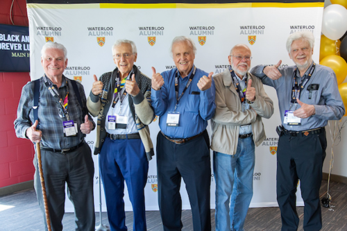 Five alum standing for a group photo
