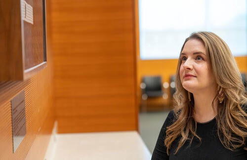 Savannah Sloat looks up at framed Wampum Belt