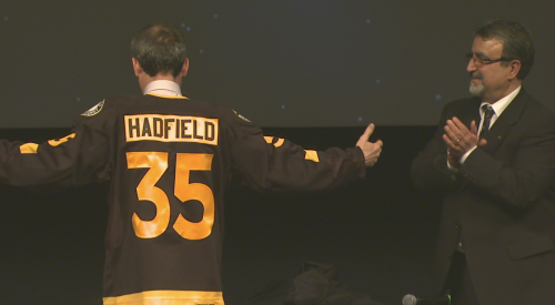 Professor Hadfield wears a Waterloo Warriors hockey jersey.