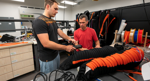 Two researchers in a lab working on compression boots