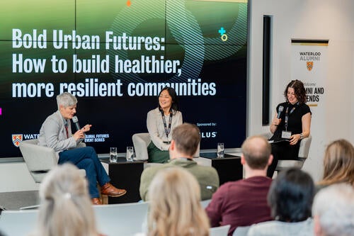 Lisa Helps speaks at the event, sitting with Dr. Joyce Kim and Dr. Leia Minaker.