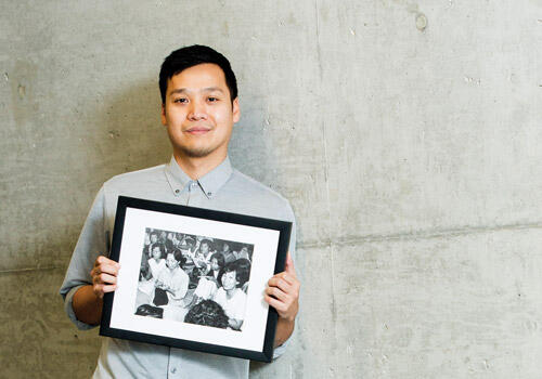 Vinh Nguyen holding a framed picture of his mother