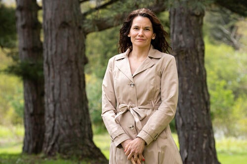 Anabela Bonada stands amongst some trees