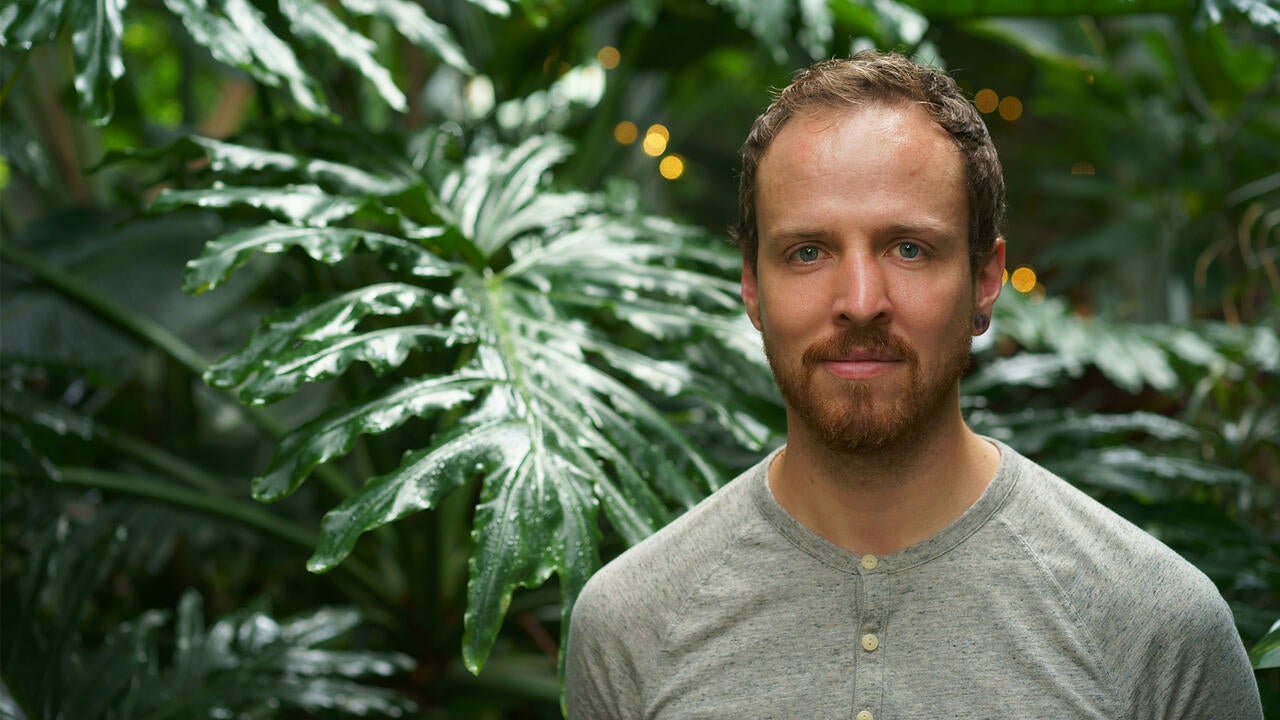 Harrison Oakes standing in front of big leaves