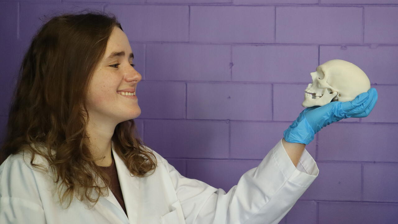 Elizabeth Diederichs, PhD candidate, holding a miniature skull that the research group 3D-printed using the new material.