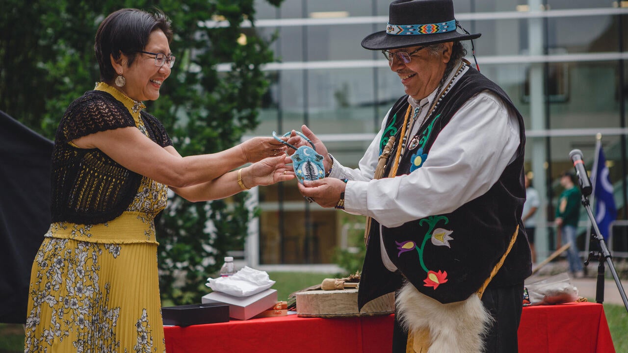 Dean Lili Liu presents Elder Henry with a beaded medallion