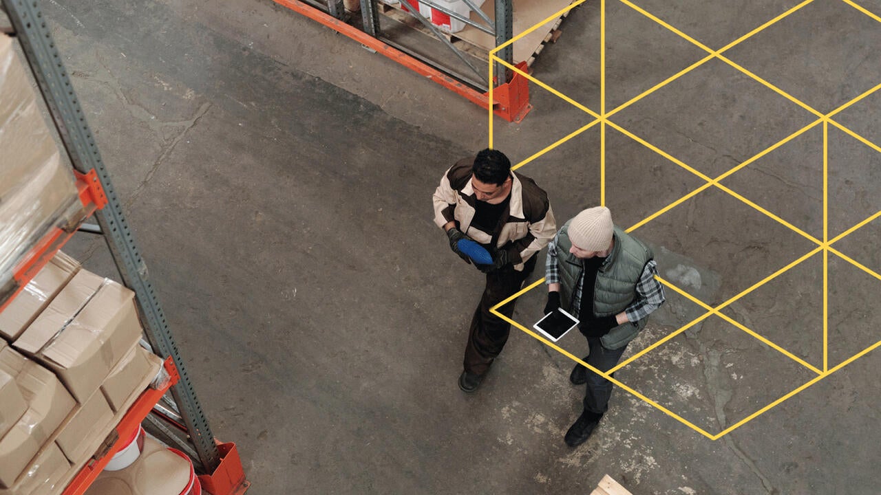 Two people working with a tablet in a warehouse