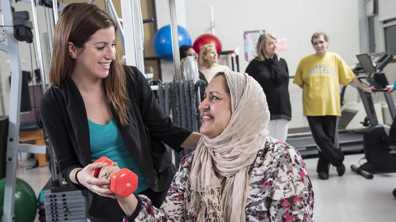 student helping woman with fitness training