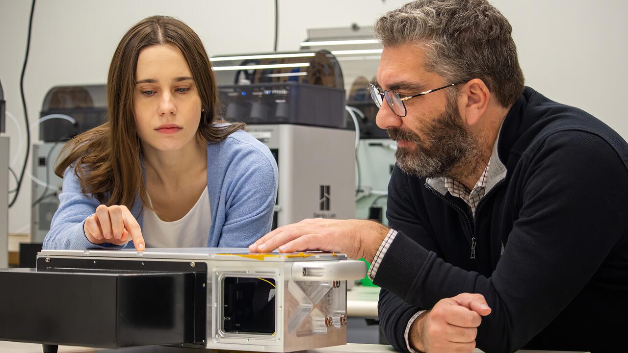 Alex Maieran examines test device in lab