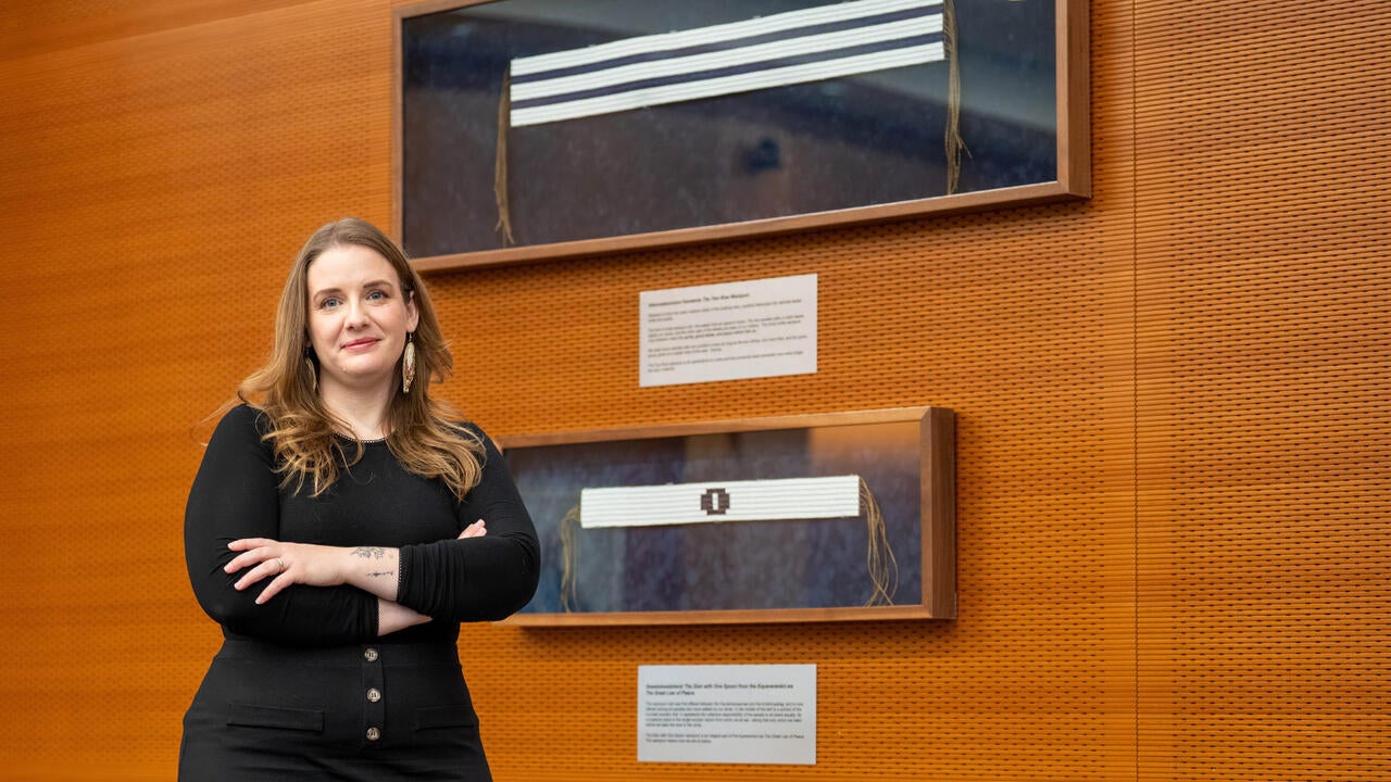 Savannah Sloat in front of framed Wampum belts