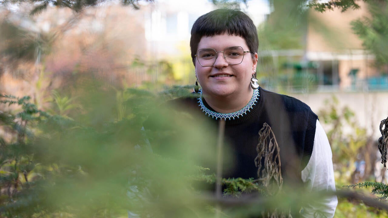 Tara Ryan looks through foliage in the woods