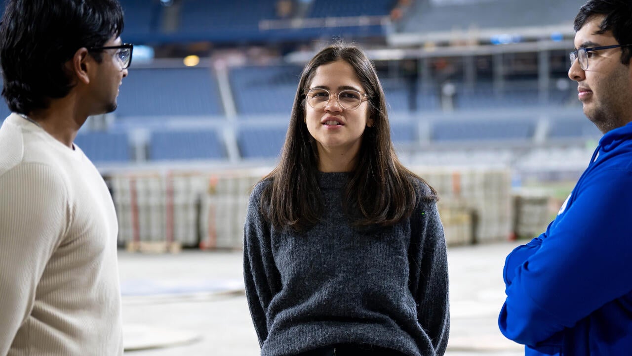 Gabrielle Campus speaks to other Waterloo alumni on the field at Rogers Centre