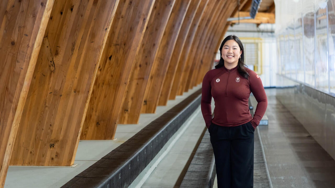Diane Choi stands in the Columbia Ice Fields rink stands while wearing COC gear