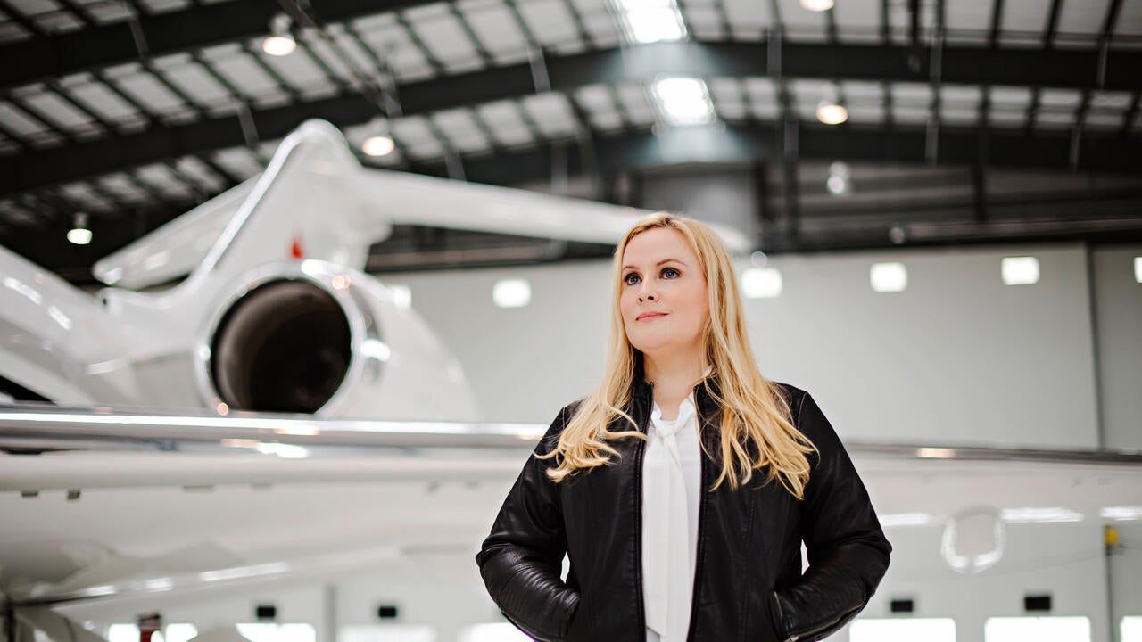Suzanne Kearns stands in front of an airplane looking up